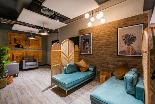 a room with a couch and chairs and a brick wall at Studios and Ensuites with Shared Kitchen at Hillfort House in Brighton in Brighton & Hove