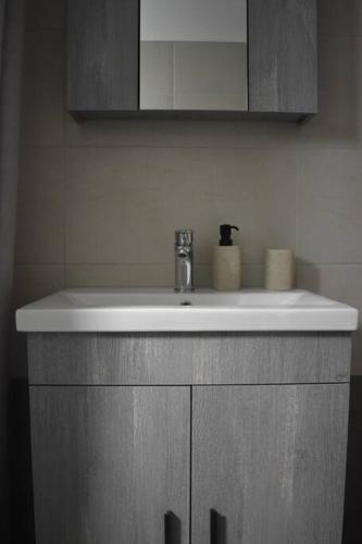 a white sink in a bathroom with a mirror at Garden House - Kastri Crete in Kastrí