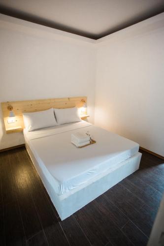 a bedroom with a white bed with a book on it at Hidden Lagoon Resort in Panglao