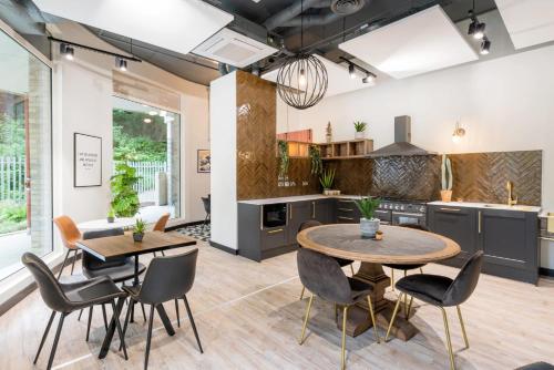 a kitchen with two tables and chairs in a room at For Students Only Modern Studios and Ensuite Bedrooms with Shared Kitchen at Hillfort House in Brighton in Brighton & Hove