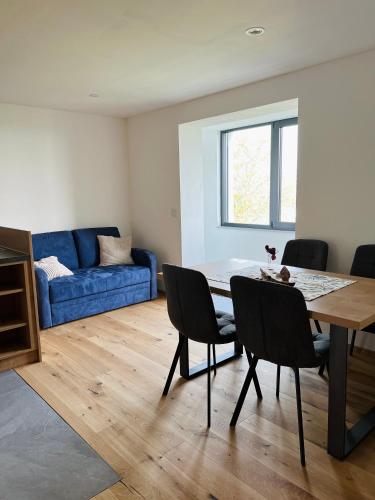 Una sala de estar con una mesa y un sofá azul. en Grünberg Apartments, en Gmunden