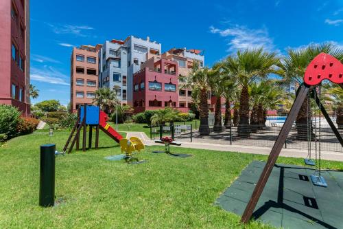 un parque con parque infantil frente a los edificios en Las Palmeras by Ĥ, en Isla del Moral