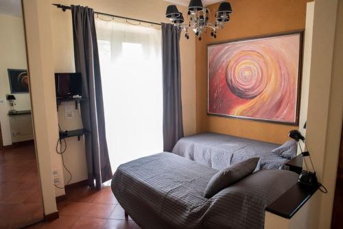 een slaapkamer met een bank en een schilderij aan de muur bij Bellavista:relax among the hills of Trasimeno lake in Tuoro sul Trasimeno