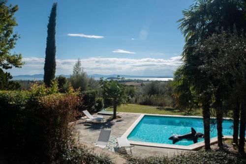 een zwembad in een tuin met bomen bij Bellavista:relax among the hills of Trasimeno lake in Tuoro sul Trasimeno