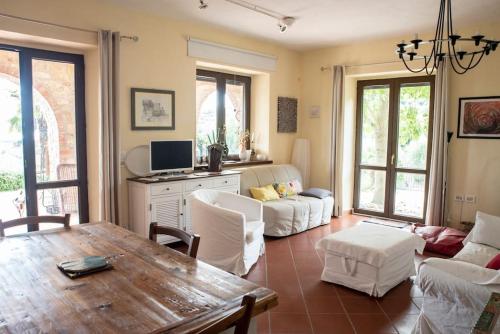 een woonkamer met een houten tafel en witte meubels bij Bellavista:relax among the hills of Trasimeno lake in Tuoro sul Trasimeno