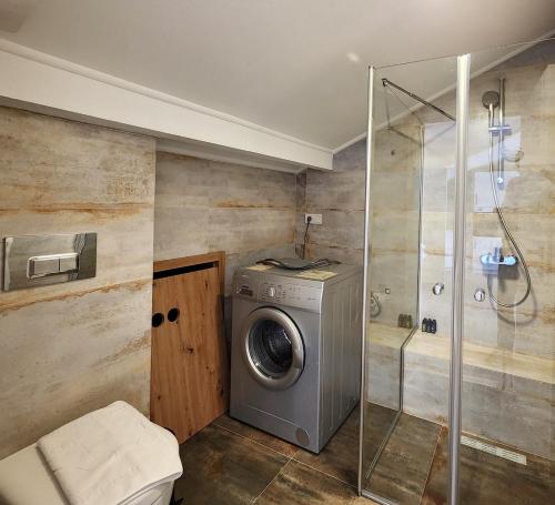 a bathroom with a washing machine and a shower at Guney Suites by Villa Safiya in Göcek