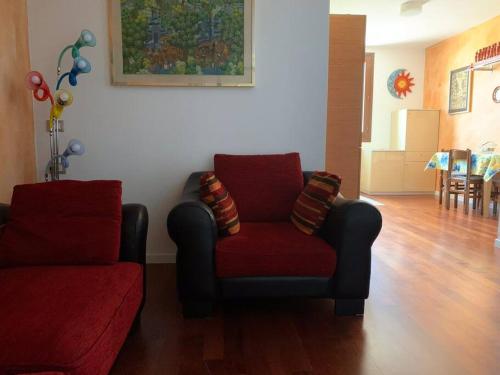a living room with a couch and a red chair at Appartamento Andrew’s house con parcheggio privato in Anzola dell'Emilia