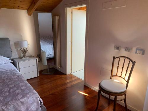 a bedroom with a bed and a chair in a room at Appartamento Andrew’s house con parcheggio privato in Anzola dell'Emilia