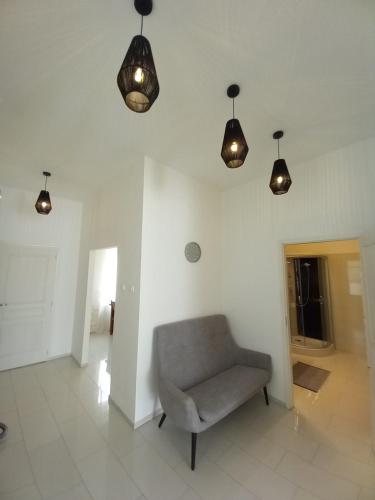 a room with a chair and lights on the ceiling at Korvin One Apartman in Pápa