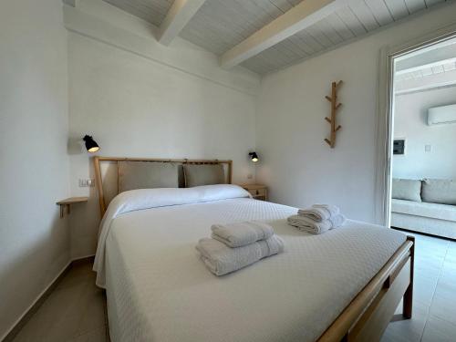 ein weißes Schlafzimmer mit 2 Betten und Handtüchern darauf in der Unterkunft Maison Céline in Syrakus