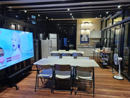 a room with tables and chairs and a large screen at 318 Stay in Seoul