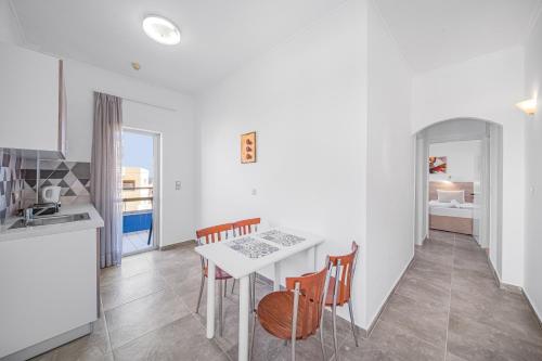 a kitchen and dining room with a table and chairs at Happy Days in Malia