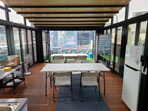 a group of tables and chairs in a room with windows at 318 Stay in Seoul