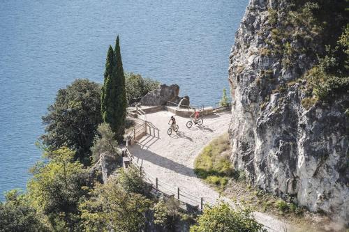 a group of people riding bikes on a path near the water at Mè Cà - Appartamento vacanze in Riva del Garda