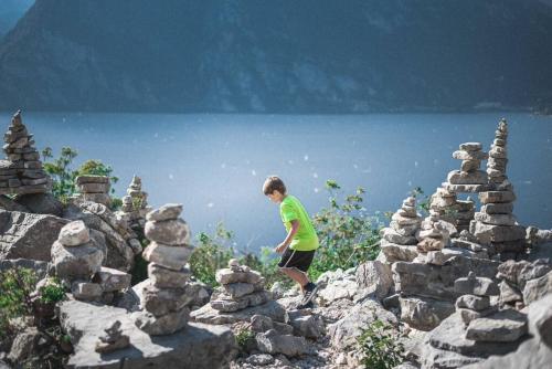 a boy standing on a pile of rocks on a mountain at Mè Cà - Appartamento vacanze in Riva del Garda