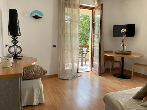 a living room with a table and a door to a patio at Residence Alexandra Stay in Sirmione