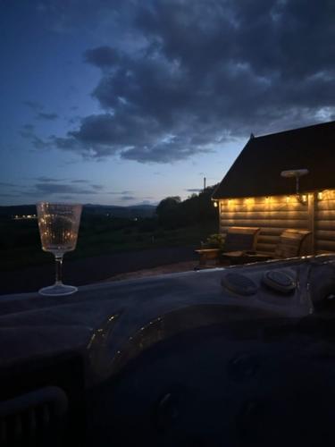 a wine glass sitting on a table in front of a house at South Barlogan Farm in Bridge of Weir