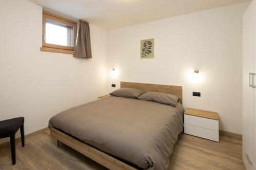 una camera con letto, scrivania e finestra di Appartamento Fede a Livigno