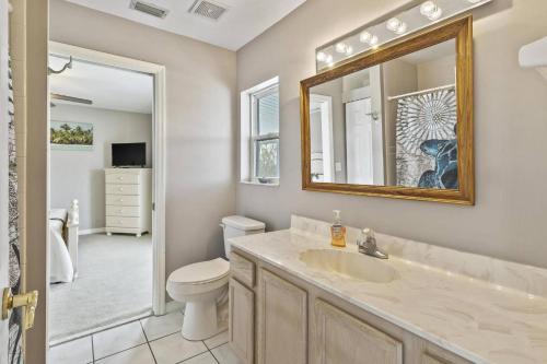a bathroom with a sink and a toilet and a mirror at Sea Forever Ocean Lookout Flagler Beach Ocean Views Pet Friendly in Flagler Beach