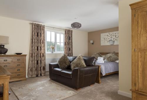 a living room with a leather chair and a bed at Holywell House 4 Guests in Wellington