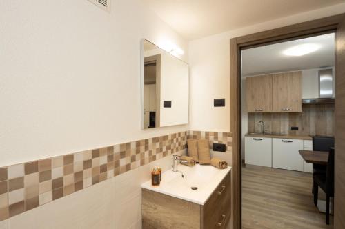 bagno con lavandino e cucina di Appartamento Fede a Livigno