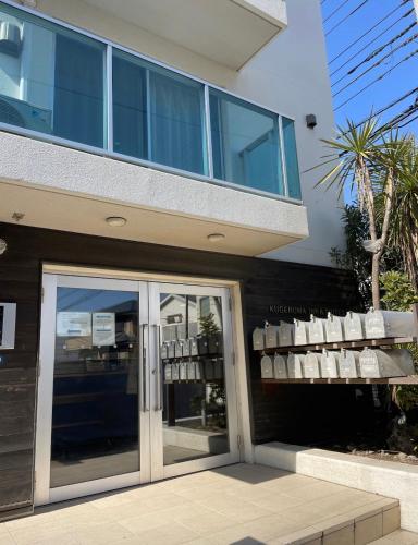 a building with a glass door with chairs on it at 镰仓、藤沢冲浪胜地 近新江之岛水族馆 距离沙滩1分钟 整套公寓 in Fujisawa