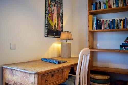 a wooden desk with a lamp and a chair at Casinhas da Figueira in Budens