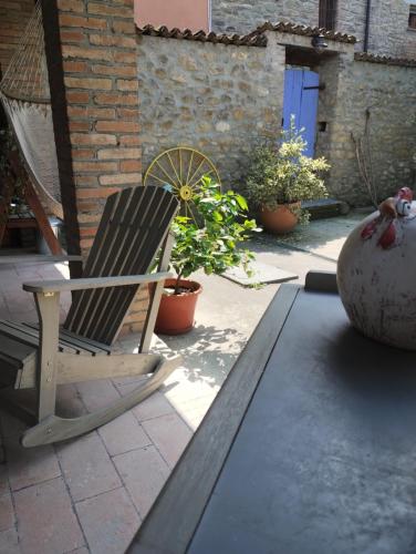 a rocking chair sitting on a patio with plants at La Pomella in Ponte Nizza