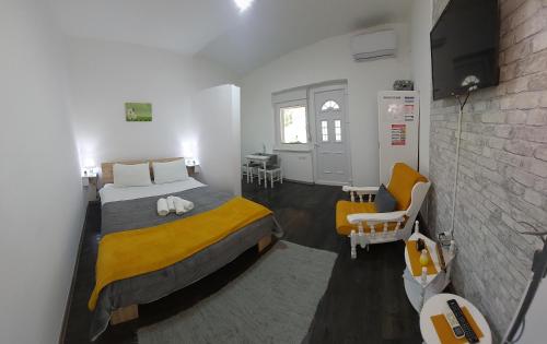 a bedroom with a bed with a yellow blanket at Apartmani Maslačak in Vrdnik