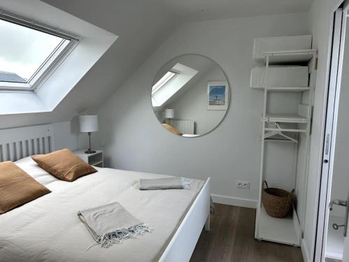 una camera bianca con letto e specchio di Charmant appartement chez Pat a Caen