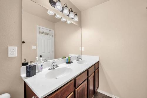 a bathroom with a sink and a large mirror at Comfy Classy Home, Close To Everything in El Paso