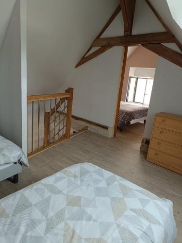 - une chambre avec un lit et un escalier dans l'établissement Gîte de la Grand Maison le Noyer, à Seigy