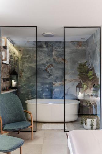 a bathroom with a bath tub and a bedroom at Armerun Heritage Hotel & Residences in Šibenik