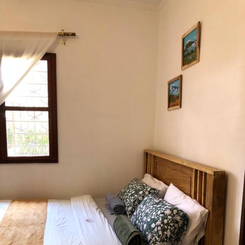 a bedroom with a bed and a window at Goodtimewithfar House in Moshi