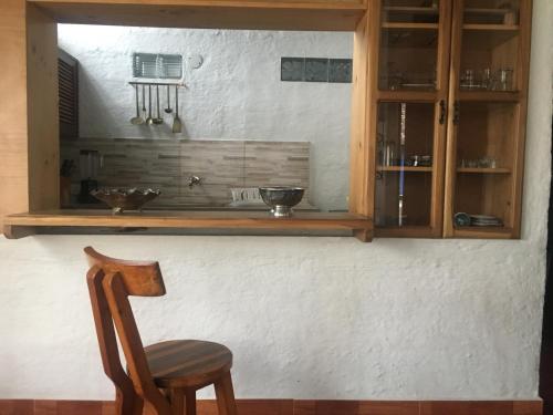 a wooden cabinet and a chair in a room at Casa típica de la Región del Café in Calarcá