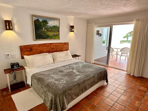 a bedroom with a large bed and a balcony at OceanBlue Resort in Christ Church