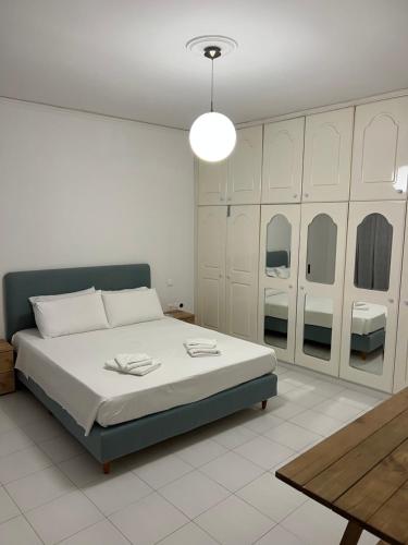 a white bedroom with a bed and a table at Johannes House in Afantou