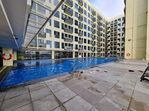 a large swimming pool in the middle of a building at Stay In Kay Kay Hotel Suite at South China Sea Place Suite in Kota Kinabalu