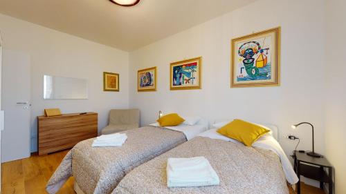 a bedroom with two beds and a dresser at Avantgard Rooms S. Orsola in Bologna