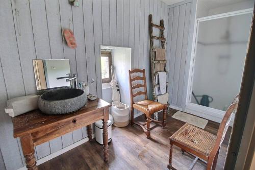 a bathroom with a stone sink on a wooden table at Maison en pierre dans le Sidobre in Le Bez