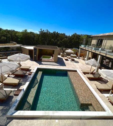 une piscine avec chaises et parasols sur un immeuble dans l'établissement La Maison d'Ambrine - La Villa Ibiza, à Chamaret