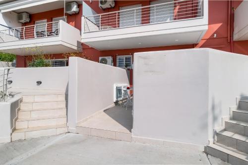a building with white walls and stairs next to a building at Mella Roa - Teal studio in Nydri