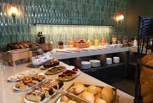 a buffet line with different types of pastries and desserts at Hotel Du Lac in Molveno