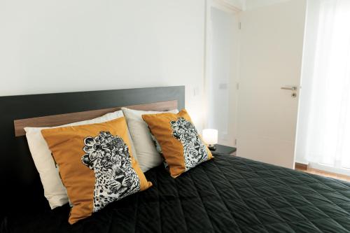 a bed with orange and white pillows on it at Gold Apartment Ferrel I in Ferrel