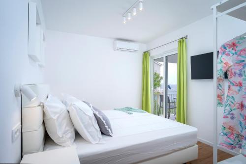 Habitación blanca con cama y ventana en Feelhvar along BlueLagoon beach en Hvar