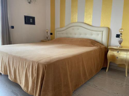 a bedroom with a large bed with a gold blanket at Residence Alexandra Stay in Sirmione
