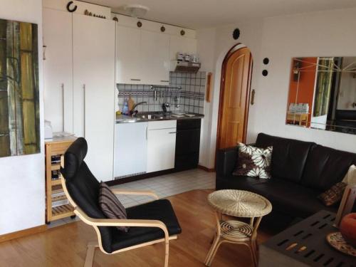 sala de estar con sofá negro y cocina en 2-Zimmer-Wohnung Deheimu mit fantastischer Aussicht en Eischoll