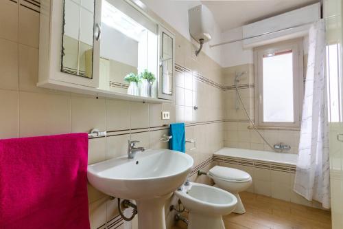 Appartamento Dafne B1 - MyHo Casa في مارتينسيكورو: حمام أبيض مع حوض ومرحاض