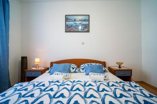 a bedroom with a bed with blue and white comforter at Sunny in Vela Luka