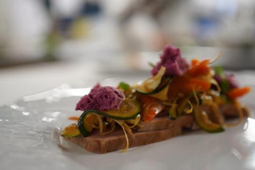 a piece of bread with vegetables on it on a table at Hotel Du Lac in Molveno